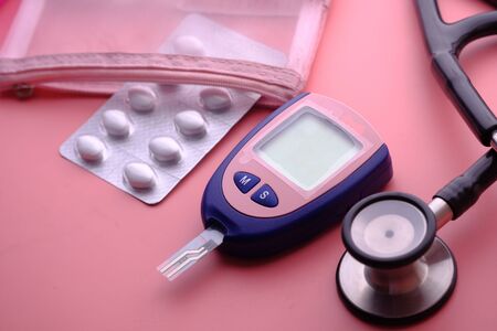 Glucometer, blood sugar measurement for diabetes, pills and stethoscope.の写真素材