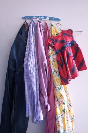 family cloths handing on wall, close upの写真素材