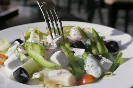 Fresh greek salad - feta cheese, tomato, lettuce, black olives and onionの写真素材