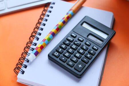 close up of calculator, notepad and pen on pink backgroundの写真素材