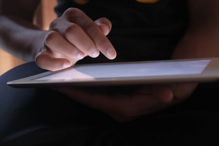Close up of mans finger touching digital tablet screenの写真素材