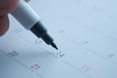 mans hand with pen marking on calendar, deadline concept