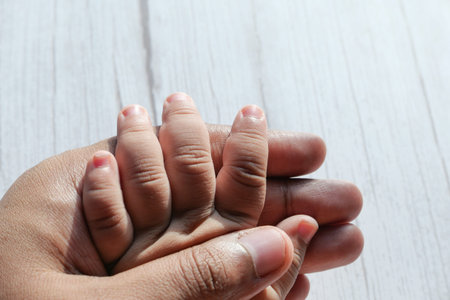 father hand holding child hand, close up