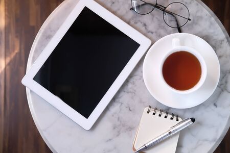 top view of s notepad digital tablet, tea on tiles backgroundの写真素材