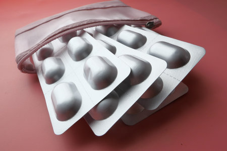 top view of blister pack in a paper box on pink background