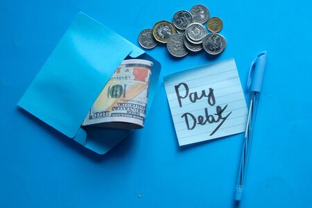 pay debt concept with cash and coinの写真素材