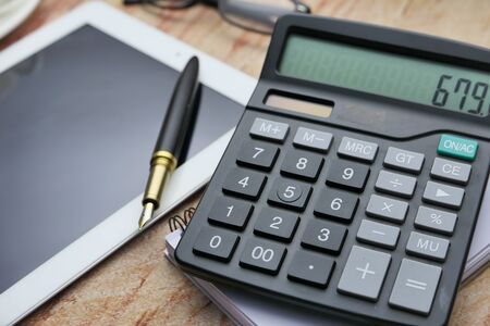 top view of calculator and pen on color backgroundの写真素材