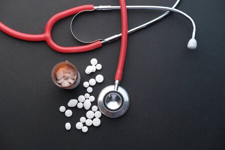 top view of stethoscope and pills on black backgroundの写真素材