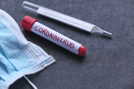 Close up of face mask , blood test tube and thermometer on color backgroundの写真素材