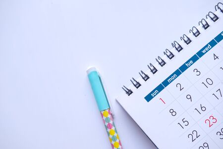 top view of calendar, pen on white backgroundの写真素材