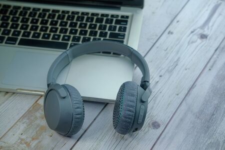 Headset or headphone on laptop with notepad on tableの写真素材