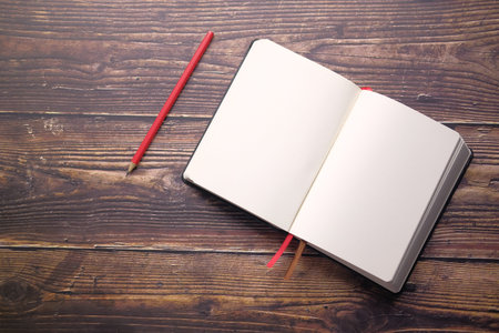 open diary with fountain pen and tea cup on table