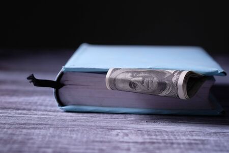 cash saved inside of a book, saving money for education conceptの写真素材