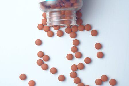 red pills spilling on white background, top viewの写真素材