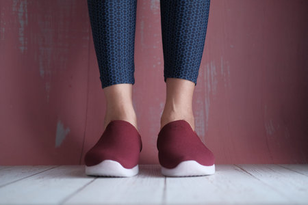Legs of beautiful woman in stylish shoes on color background