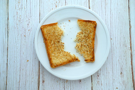 Half slice of white bread on plate, top view
