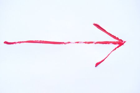 Red hand painted arrow with brush strokes isolated on the white background.の写真素材