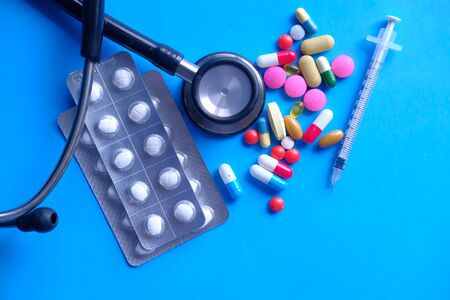 colorful pills , stethoscope and syringe on blue backgroundの写真素材