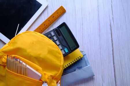 top view of school bag with school suppliers on tableの写真素材