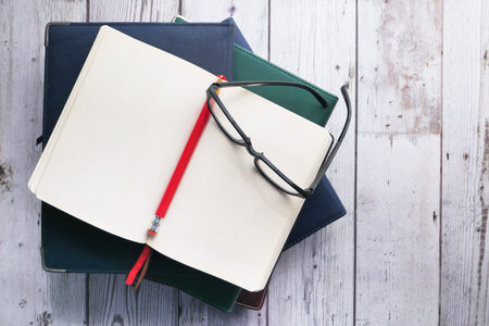 notebook stack on wood background, top view