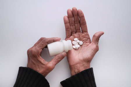 top view of senior women taking pills.