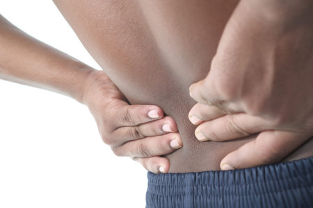 Back pain, close up young man has injury during outdoor exercise