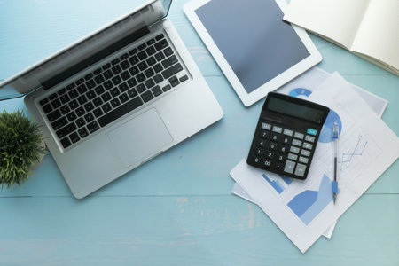 top view of digital tablet, laptop, pen and notepad on wooden table