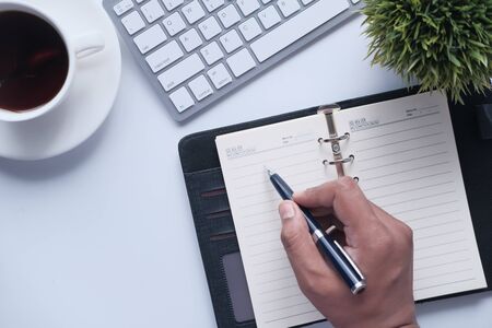 top view of man writing on notepadの写真素材