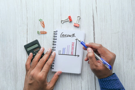 man analyzing growth chart on notepad indoorの写真素材