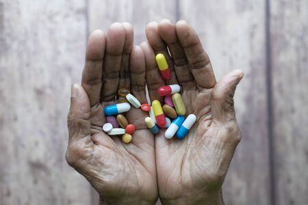 Senior adult woman hand pouring medicine from bottle.の写真素材