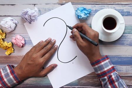 high angle view of man hand drawing question markの写真素材