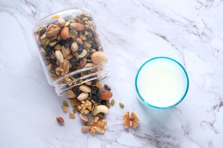 close up of mixed nut in a bowl and milk on tableの写真素材
