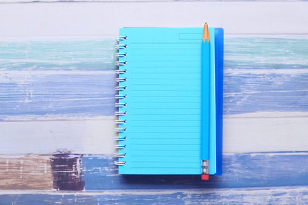 high angle view of open notepad and pencils on tableの写真素材