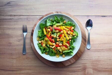 Fresh bright fitness salad and spoon on table .の写真素材