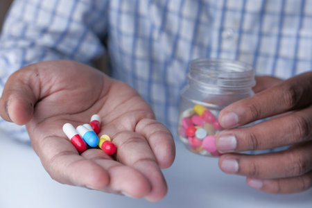 high angle view of pills and container on handの写真素材