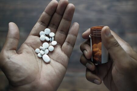 high angle view of pills and container on handの写真素材