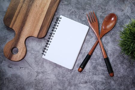 chopping board with wooden fork and spoon on white tableの写真素材