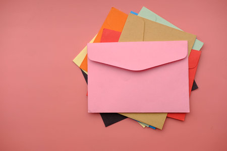 high angle view of colorful envelope pink background
