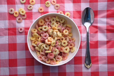colorful ring corn flakes in a bowl on table cloth.