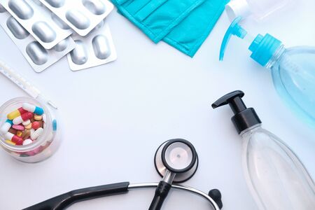 hand sanitizer, mask, stethoscope and pills on whiteの写真素材