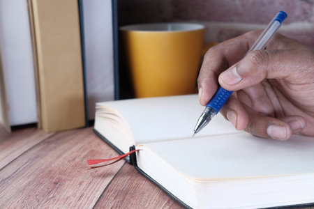 close up of businessman hand writing on notepad