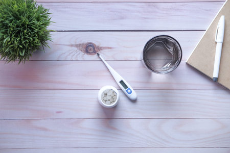 top view of digital thermometer, contianer and water bottle on table
