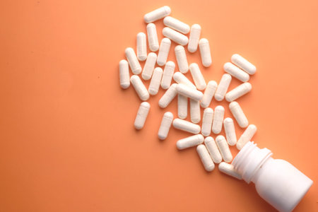 bottle of white capsule on orange background