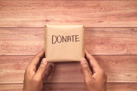 man hand holding donation box, top viewの写真素材