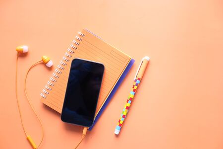 smart phone and earphone on orange background .の写真素材