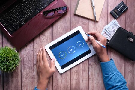 person hand analyzing financial data on digital tabletの写真素材