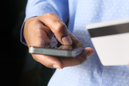 Man holding credit card and using smart phone, online shopping concept
