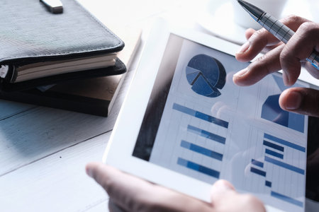 person hand analyzing financial data in digital tabletの写真素材