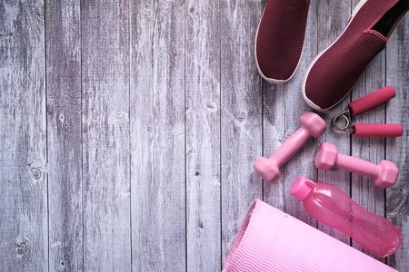 Top view of dumbbell, shoe and exercise mat on tableの写真素材