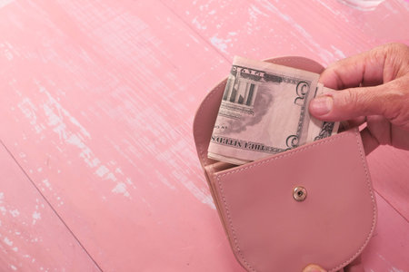senior women hand saving cash in wallet.